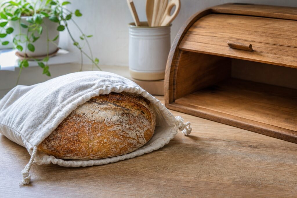 Pane fatto in casa raffreddato in un sacchetto di cotone accanto al portapane